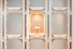 An open locker with a wooden wall and a lit cup inside, showcasing minimalist design in a technological setting.