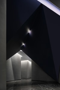 Modern interior design featuring concrete walls and ceiling in a corporate office entryway.