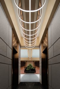 A modern lounge area featuring metal elements and geometric lighting fixtures.
