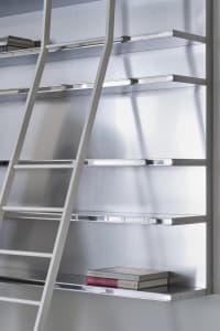 A metal shelving unit with a ladder on a white wall.
