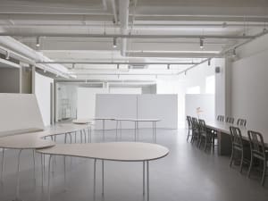 An empty, minimalist office space with white walls and furniture.