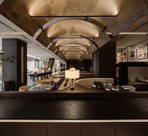 Modern restaurant with metallic ceiling and tables, featuring contemporary design elements.