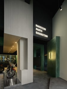 A motorcycle exhibition space featuring metallic, concrete, and wooden elements.
