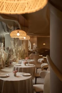 Well-lit restaurant interior featuring modern design with textured wood and concrete elements.