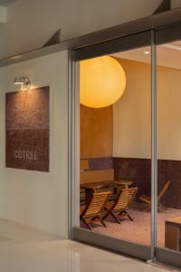 Modern cafe interior with wooden seating and a large spherical light fixture.