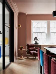 Modern residential dining room featuring wooden floor, leather chairs, and metallic accents.