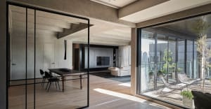 Contemporary residential interior featuring hardwood flooring and floor-to-ceiling windows.