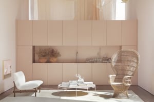 A modern living room with a minimalist design, featuring neutral-toned furniture and decor, and a central coffee table.