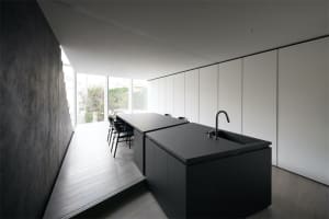 Modern minimalist interior with black marble countertops and concrete walls.