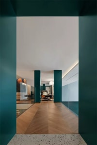 Modern interior corridor featuring blue-green pillars and terrazzo tiles floor
