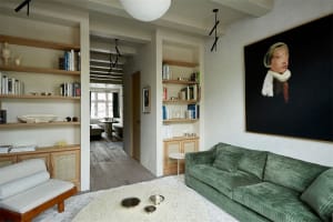 A modern living room with wooden furniture and a green sofa.