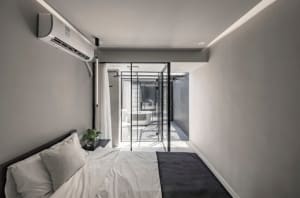 Modern bedroom featuring concrete walls and glass elements