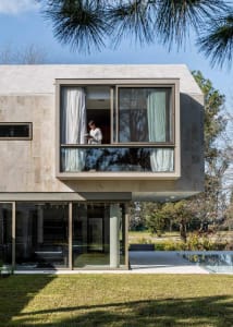 A modern residential building with a concrete facade and large windows.