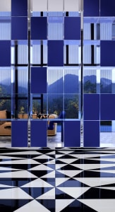 A modern living room with dark blue and white glass tiles on the floor and blue and white geometric patterns on the ceiling.