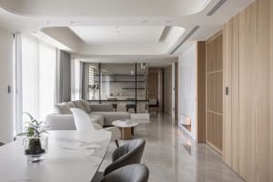 Modern living room with marble floor, sofa, and glass partition