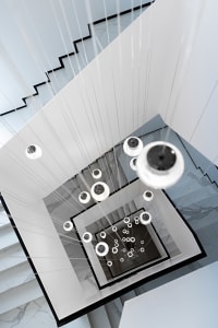 A minimalist modern interior featuring large glass light fixtures hanging from the ceiling.