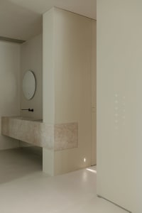 A modern minimalist bathroom with marble finishes and sleek, contemporary fixtures and fittings.