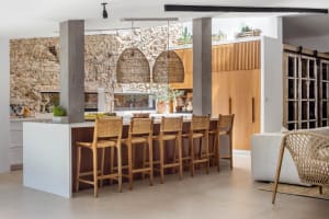 A modern residential kitchen with wooden furniture and flooring.