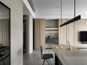 Modern residential kitchen featuring a wooden finish with black pendant lights and a minimalist design.