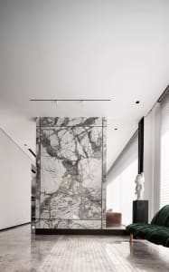 Modern living room featuring marble walls and floor, minimalist decor, and large windows.