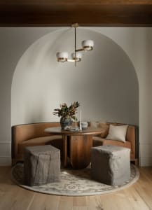 A cozy, curved seating arrangement with a wooden table in a dining room setting.