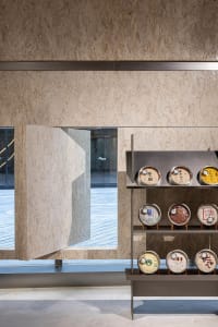 Modern interior with wooden shelving displaying various decor items.