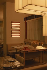 Warm and inviting restaurant interior with white walls, red bowls, and comfortable seating