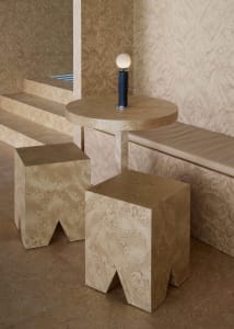 Warm and inviting interior design featuring wooden elements, a table, bench, and stairs, with a lamp on a wooden block