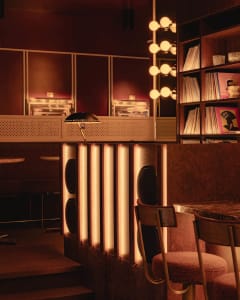 Modern interior design with a bar area featuring a countertop, sink, chairs, and a bookshelf, creating a cozy atmosphere