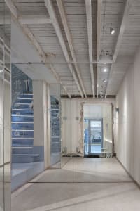 A calm and inviting open space with a staircase and two doors, possibly in a museum or multi-level building