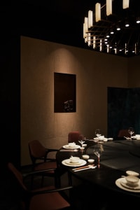 Elegant dining area with a round table, wooden ceiling, and fine china and glassware