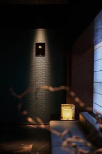 Dimly lit room with a small table, two chairs, and a candle creating a cozy atmosphere