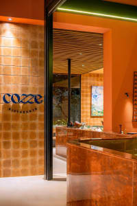 A cozy restaurant dining area with a marble countertop, brown tile walls, and various bottles placed around the room
