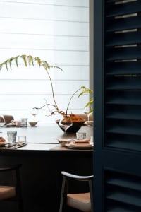 Elegant dining area with a wooden table, chairs, wine glasses, and tableware