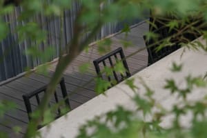 A casual outdoor patio scene with a wooden dining table and several chairs, perfect for enjoying meals or spending time outdoors
