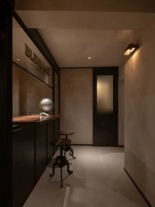 Cozy bar area with a countertop, globe, and two chairs, featuring a sophisticated atmosphere