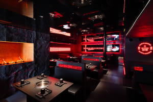 Modern restaurant dining area with multiple TV screens, tables, and chairs, creating a comfortable and inviting atmosphere