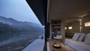 Cozy open concept living area with couches, a chair, and a coffee table with fruits, set against a warm and inviting atmosphere