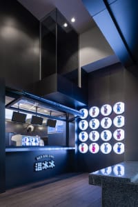A lively restaurant interior with black walls, brightly lit, and teddy bears arranged around the area