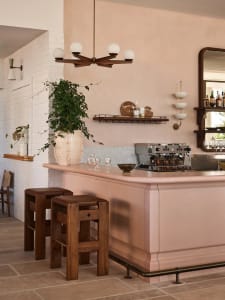 Inviting bar area with a pink countertop, chairs, and bottles, set in a restaurant