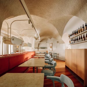 Cozy dining area in a basement with a vaulted ceiling, featuring several tables and chairs