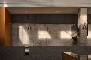 A bathroom scene with four people in the shower area, surrounded by stone walls and a relaxed atmosphere
