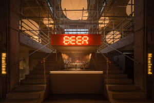Casual industrial bar with beer taps, wooden accents, and a large sign reading Beer