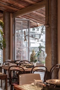 A well-lit restaurant interior with modern dining tables and chairs, creating a comfortable atmosphere for guests