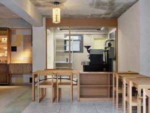 Industrial dining space with wooden tables and chairs arranged in rows, creating a modern and minimalist atmosphere with clean lines and a focus on functionality