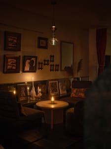 Cozy modern dining space with a dining table, two couches, and a candle, dimly lit for ambiance