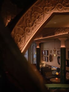 Ornate interior design with a vaulted ceiling, two chairs, and candles creating a warm and luxurious ambiance