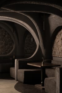 Inviting restaurant interior with stone walls, cement elements, and comfortable seating areas