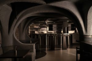 Cozy restaurant interior with stone walls, circular design, and comfortable seating for guests