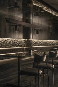 Modern restaurant bar with black leather chairs and tables, surrounded by a stylish and sophisticated atmosphere